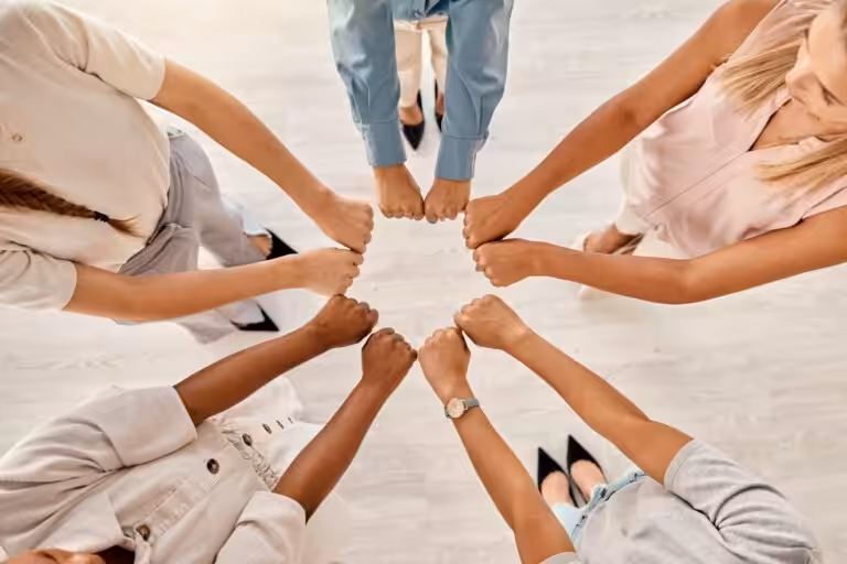 Team bildet Kreis mit gefassten Händen.