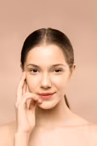 Junge Frau legt die Finger an die Schläfe und lächelt zufrieden